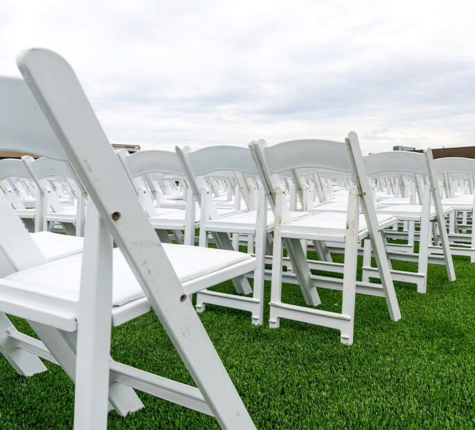 White chairs outside on beautiful artificial turf